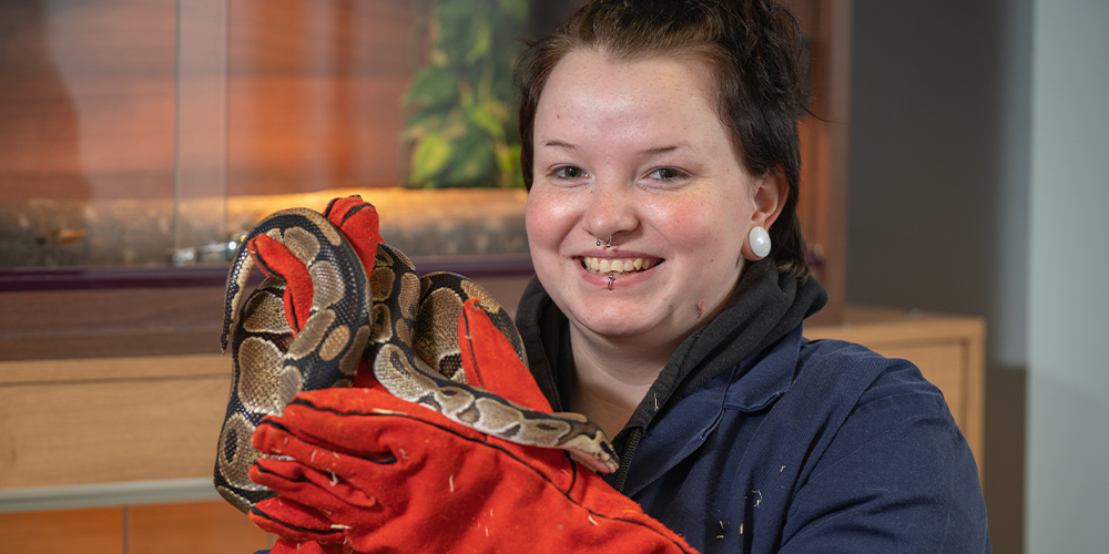 Female Jobs Growth Wales+ animal care learner holding a snake